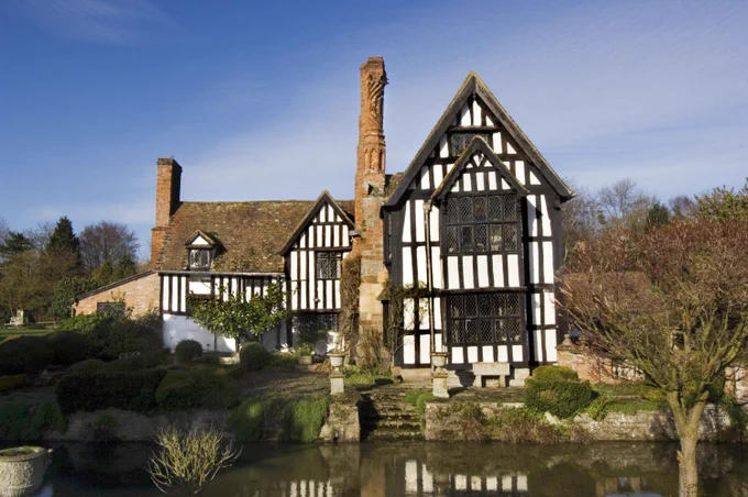 A photograph of a large 2-storey timber-framed house.