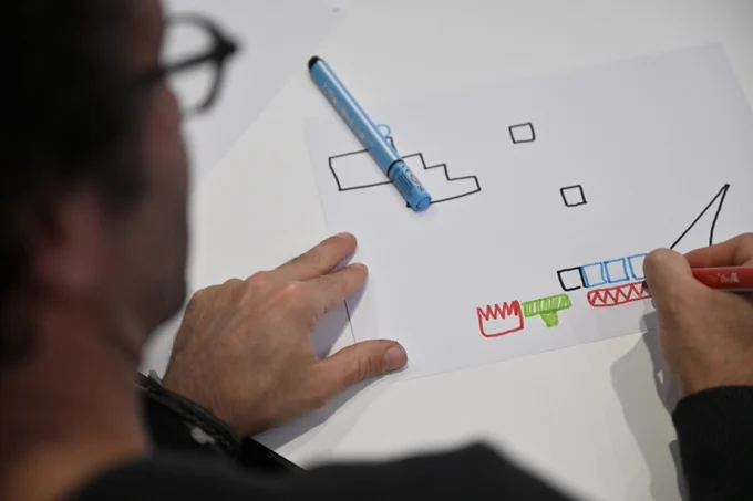A parent draws his own video game level using 4 markers (red, black, blue and green), then photographs and plays it using the Draw Your Game Infinite application.
