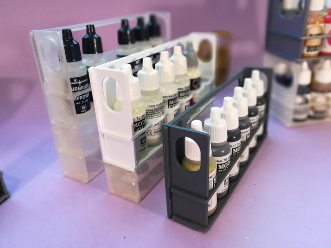Side view of 3 stands for Vallejo paints. The two at the background are stacked upon other empty stands of varying heights, so they have a stepping stair-like disposition, allowing easy access to the rearmost bottles.