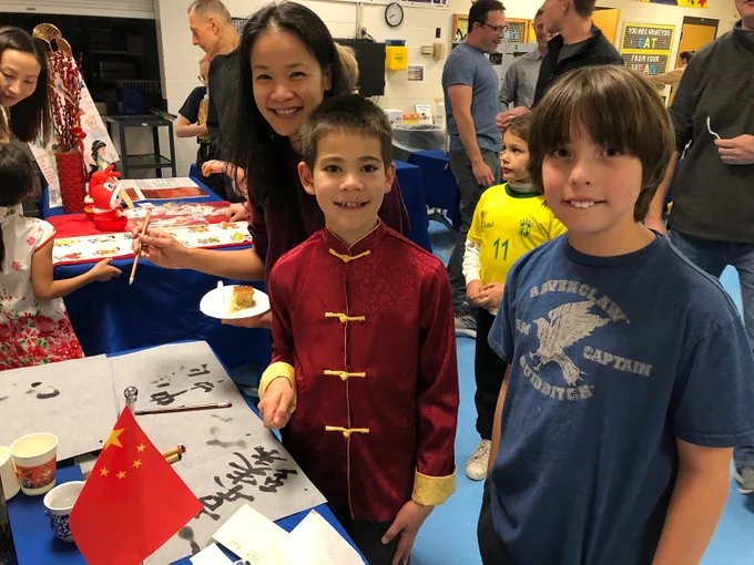 Two Rockwood students and a community member smile at their school's International Night.
