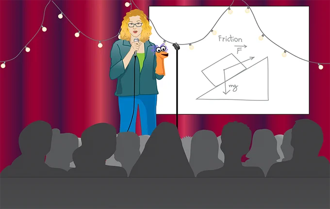 A cartoon of a woman standing on a stage in front of a live audience. The woman has blonde hair, wears glasses, and has on a green t-shirt and blue trousers. The woman is holding a microphone in her right hand and has an orange puppet with purple hair and googly eyes on he left hand.