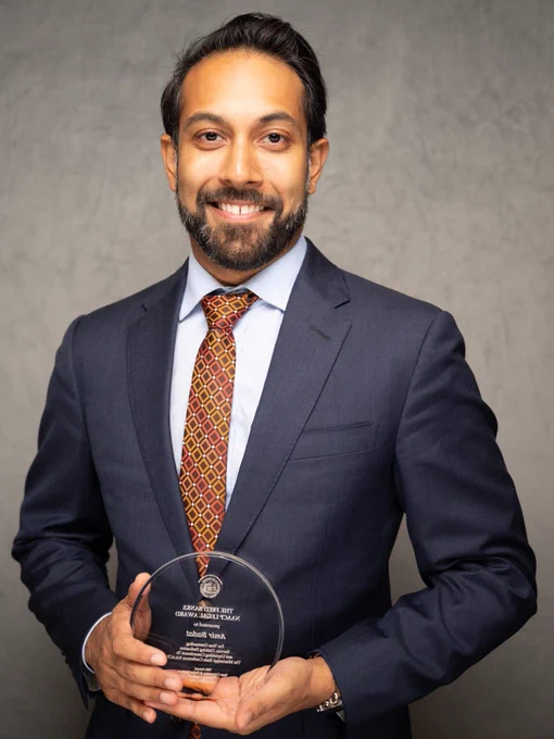 Amir Badat standing with his award