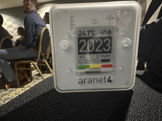 Carbon dioxide monitor on a chair in a session reads 2023 ppm (in the red zone).