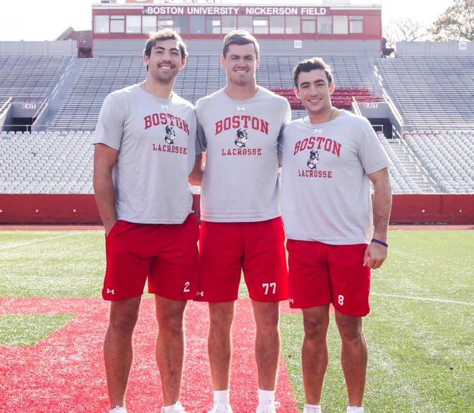Thomas Niedringhaus, Patrick Morrison and Louis Perfetto pose together at midfield of Nickerson Field.