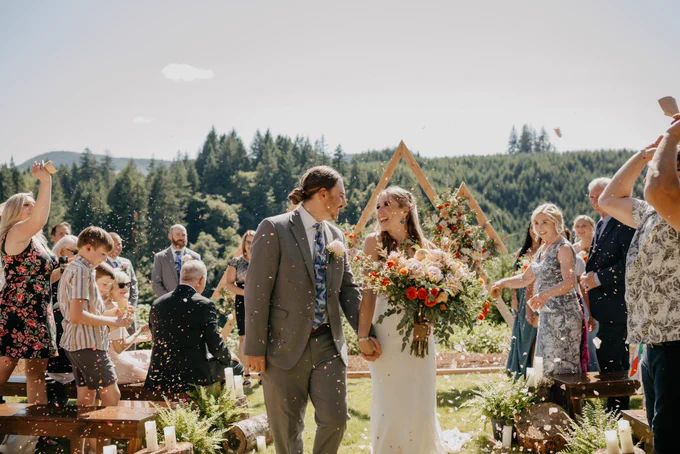 Just married as rose petals fly and newlyweds gaze into each others eyes