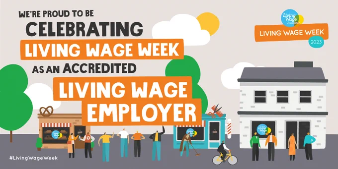 Cartoon street scene with road, trees, groups of people, a cyclist, and a Living Wage bakery, barber and office. ‘We’re proud to be celebrating Living Wage Week as an accredited Living Wage Employer’. #LivingWageWeek. 