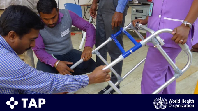 Primary health personnel in India adjusting walking frame height.