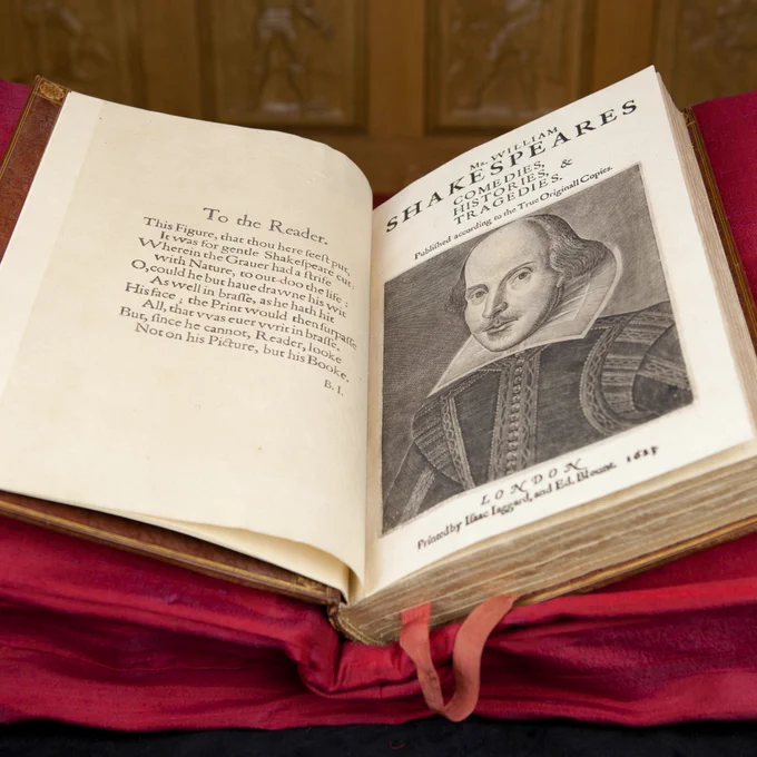 A copy of the First Folio open at a double page spread of the 'To the Reader' and the portrait of William Shakespeare.