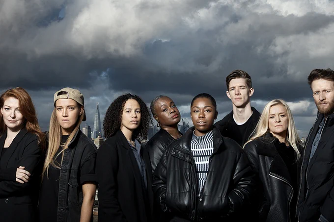 A photo showing a group of performers against a London skyline