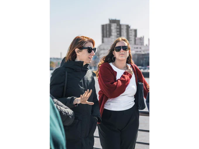 professor lecturing on a city street with a student beside her