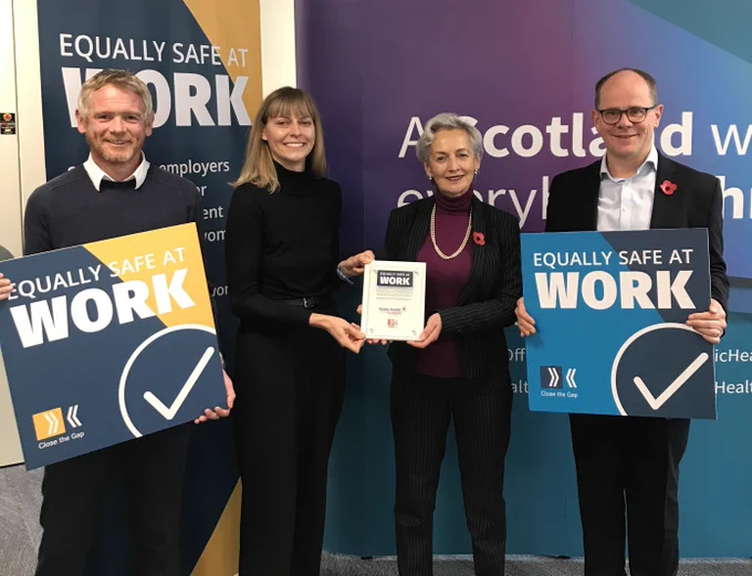 A group photo celebrating Equally Safe at Work with Kevin Campbell (PHS), Kelsey Smith (EQSW), Angiolina Foster (PHS Chair) and Paul Johnston (PHS Chief Exec). 