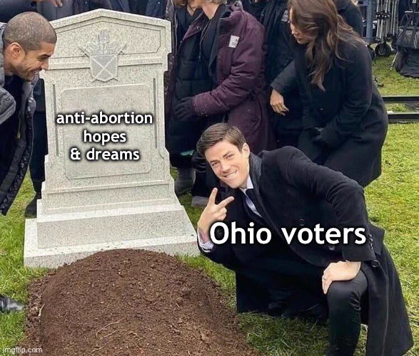 Meme of someone standing next to a fake grave making a peace sign. The person making a peace sign is labeled "Ohio voters," and the fake grave is labeled, "anti-abortion hopes and dreams"