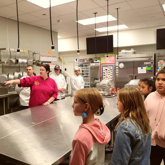 Students taking a tour of the kitchen with culinary teacher and students leading the tour.