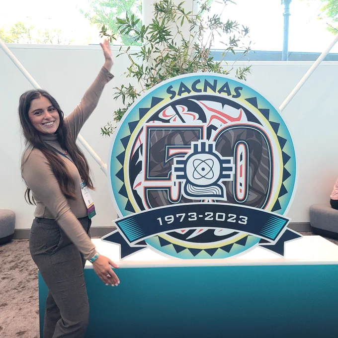 Nicole Doran in front of the SACNAS sign at the 2023 event.