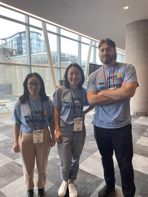 Three conference volunteers stand in the lobby of the Halifax Convention Centre
