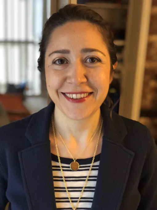 This is a headshot of Dr. Ipek Oruç. She is wearing navy business attire. She has brown hair and is smiling into the camera.