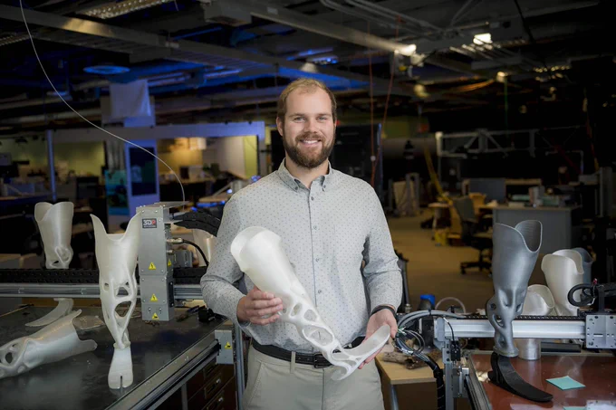 Joshua Pelz holds a prosthetic lower leg.