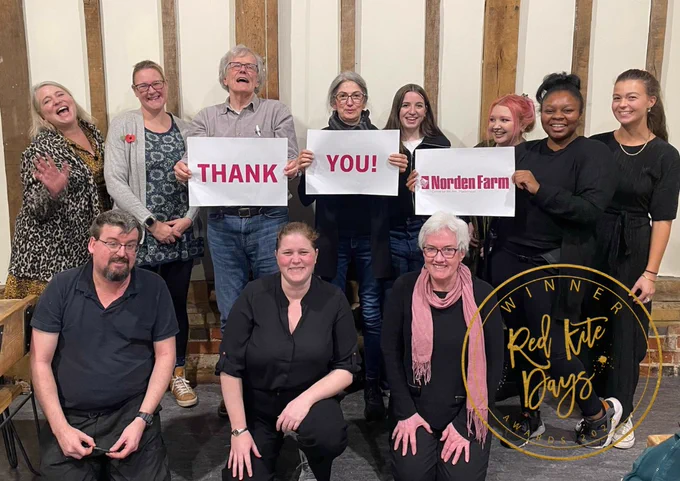 Staff at Norden Farm holding a sign which reads Thank You! Norden Farm. Sign Overlay Winner Red Kite Days Awards 2023. 