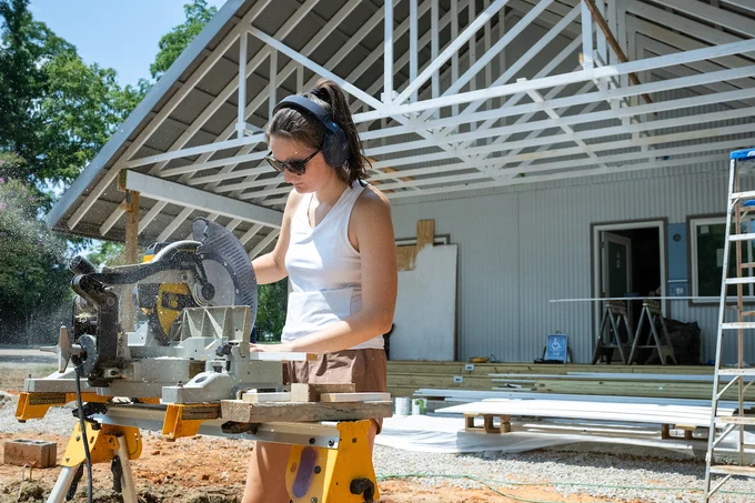 An Auburn student works with a circular saw at a Rural Studio design and build project in Newbern, Alabama.