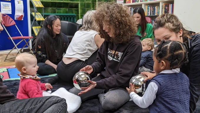 A group of women and children in the library
