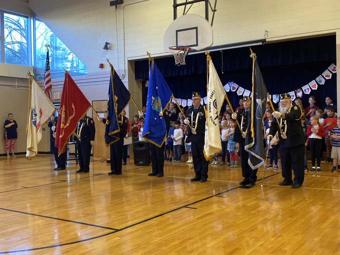 color guard from the vfw stands at attention with the flags raised