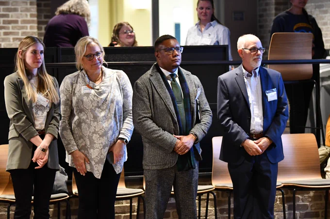 Dean Clarence Lang standing among fellow first-gen faculty.