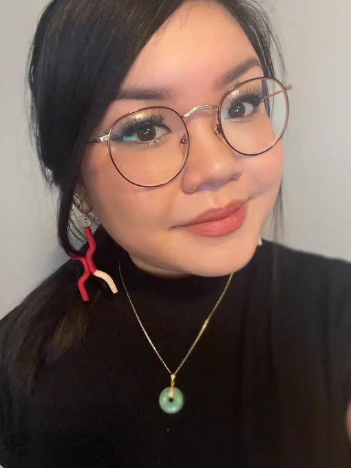 Selfie of Leann wearing chromesome-shaped earring that are red and tan