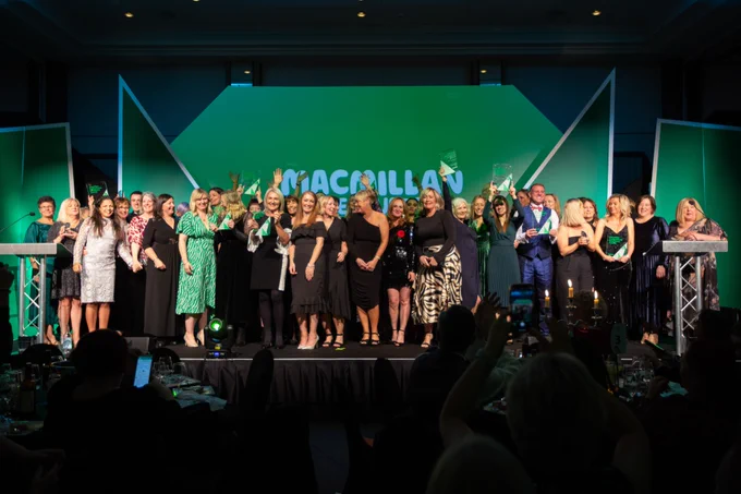 Macmillan professional award winners standing on stage smiling