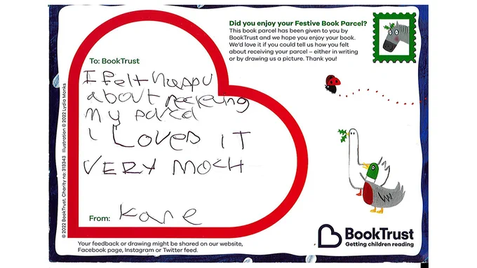 A postcard from Kane reading: "I felt happy about receiving my parcel I loved it very much" in a child's handwriting