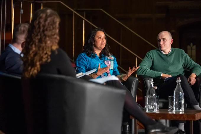 Gnisha Bevan sat on stage talking whilst Ed Atkins looks on.