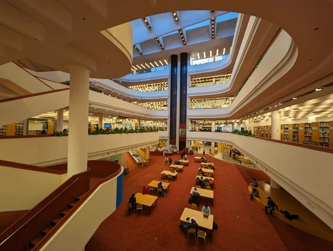 A photo of the interior of the Toronto Reference Library, showing multiple floors of tables and shelves of books.