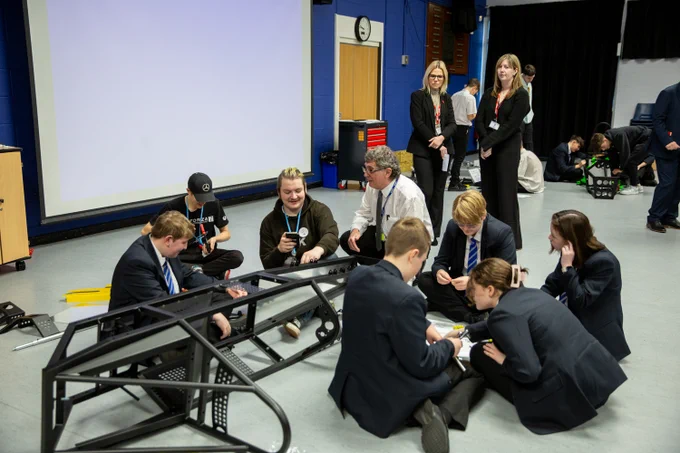 Team of pupils working on constructing electric car