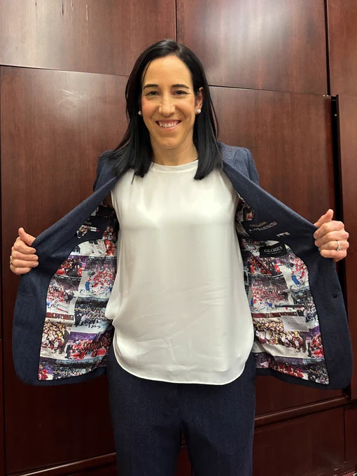 Caroline Ouellette holds her suit jacket open to show the inside lining featuring photos from across her career.