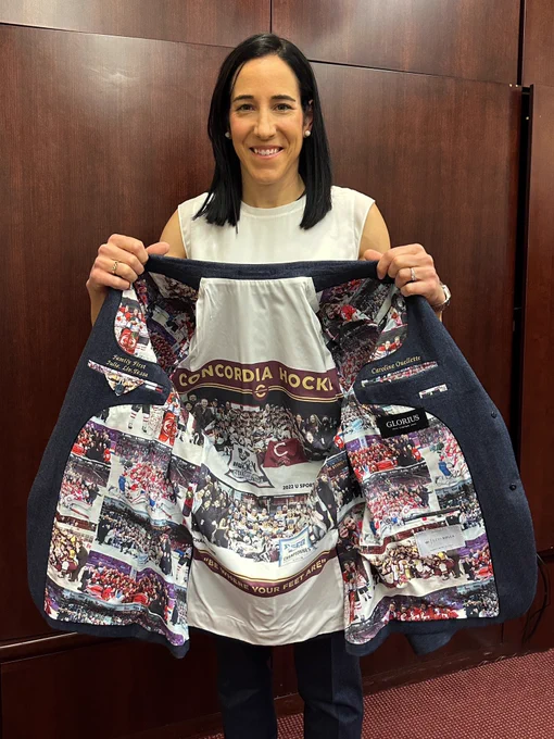 Caroline Ouellette holds her suit jacket to show the inside lining featuring photos from across her career.