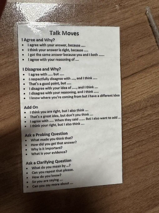 Laminated sheet titled "Talk Moves." Below are lists of sentence stems, grouped in categories titled "I agree and why?," I disagree and why?," "Add On," "Ask a Probing Question," and "Ask a Clarifying Question"