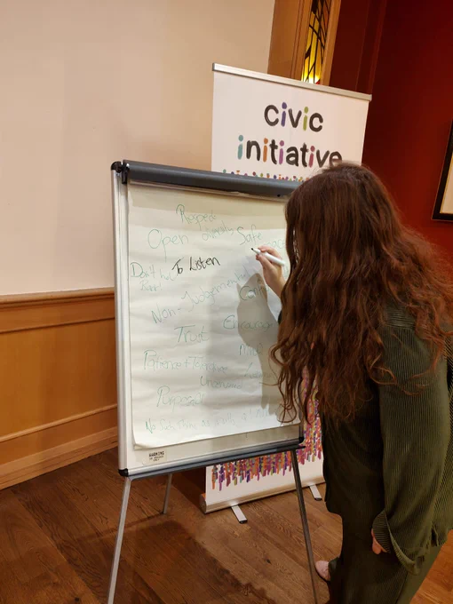 Emma writing on a flupchart 