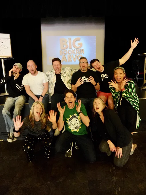A rag tag group of authors posed in front of stage pulling funny faces. Big Bookish Arvo logo in the background