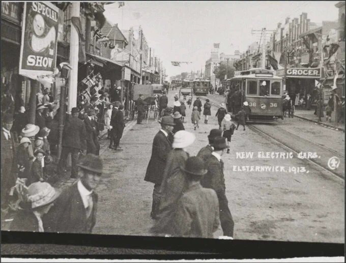Picture of crowds welcoming new trams in Glen Huntly Road. Caption says "New electric cars, Elsternwick 1913"