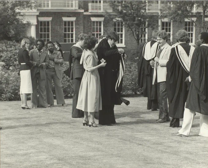 Black and white images of students graduating in 1980, centre of image shows a loved one fixing a graduates gown 