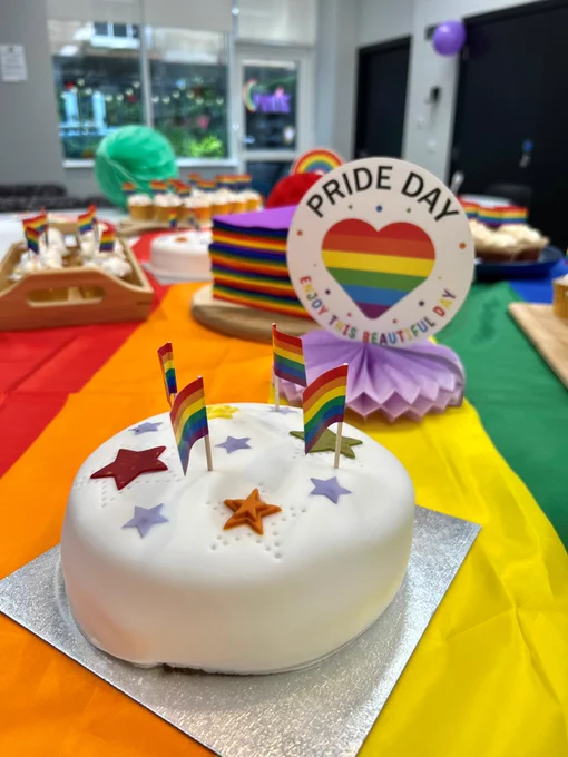 Pride decorations and cakes are displayed in a kitchen. 
