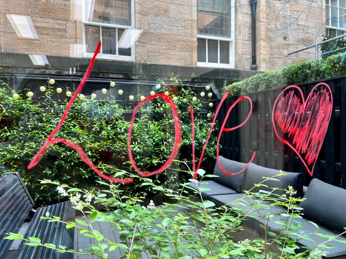 Love is written on red on a window. 