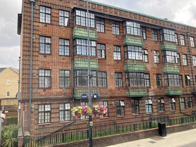 Brick construction flats with green tiled bay windows and many decorative details