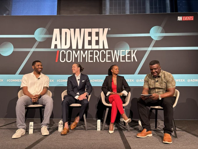 Four people sitting in chairs on stage 