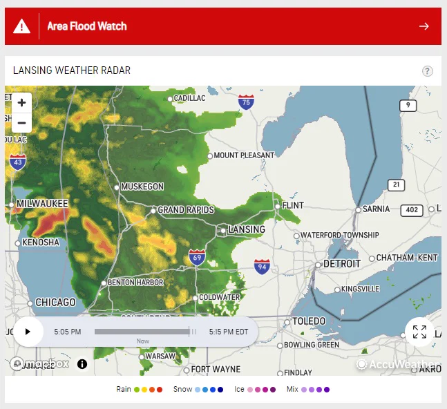 Weather map showing a large rain storm moving from West to East over the state of Michigan. Also a red banner reading "Area Flood Watch"