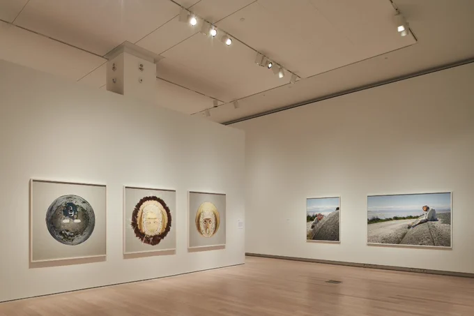 A photograph of Jin-me Yoon’s Scotiabank Photography Award Exhibition, two walls feature large hanging photographs. 