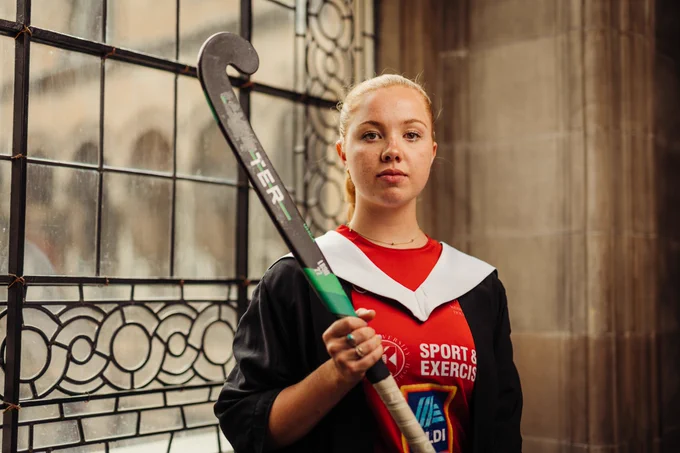  Eilidh Campbell with a hockey stick in her graduation gown