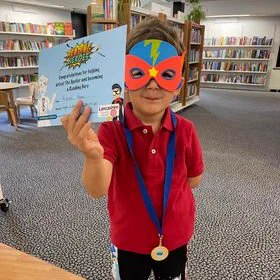 A child with a Reading Heroes certificate.