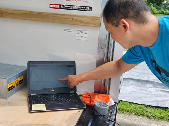 A UAlbany researcher points to weather data on a laptop.
