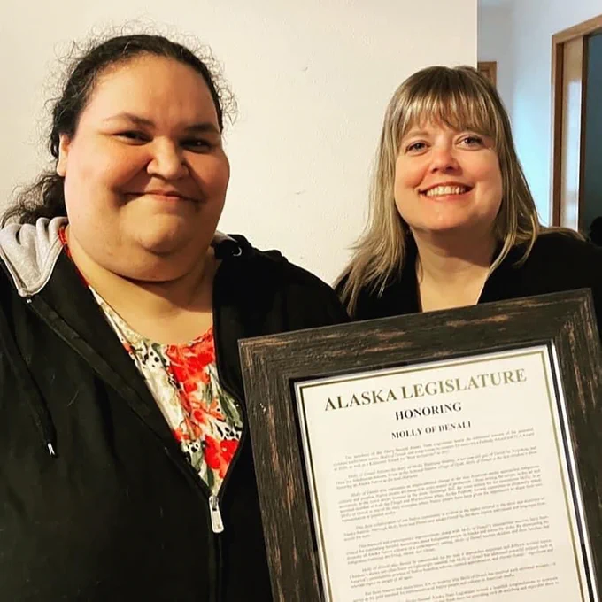 Former Alaska Rep. Geran Tarr presents an official Alaska State Legislature document honoring GBH's Molly of Denali to show writer Vera Starbard in Juneau, Alaska.
