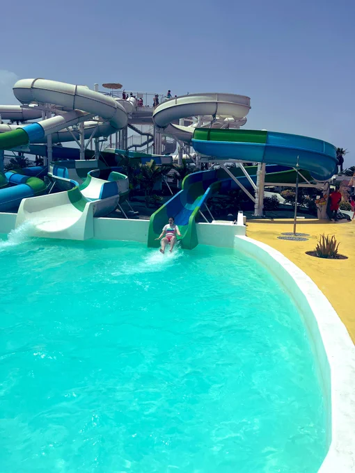 Aoife coming off a winding slide into a pool of water water